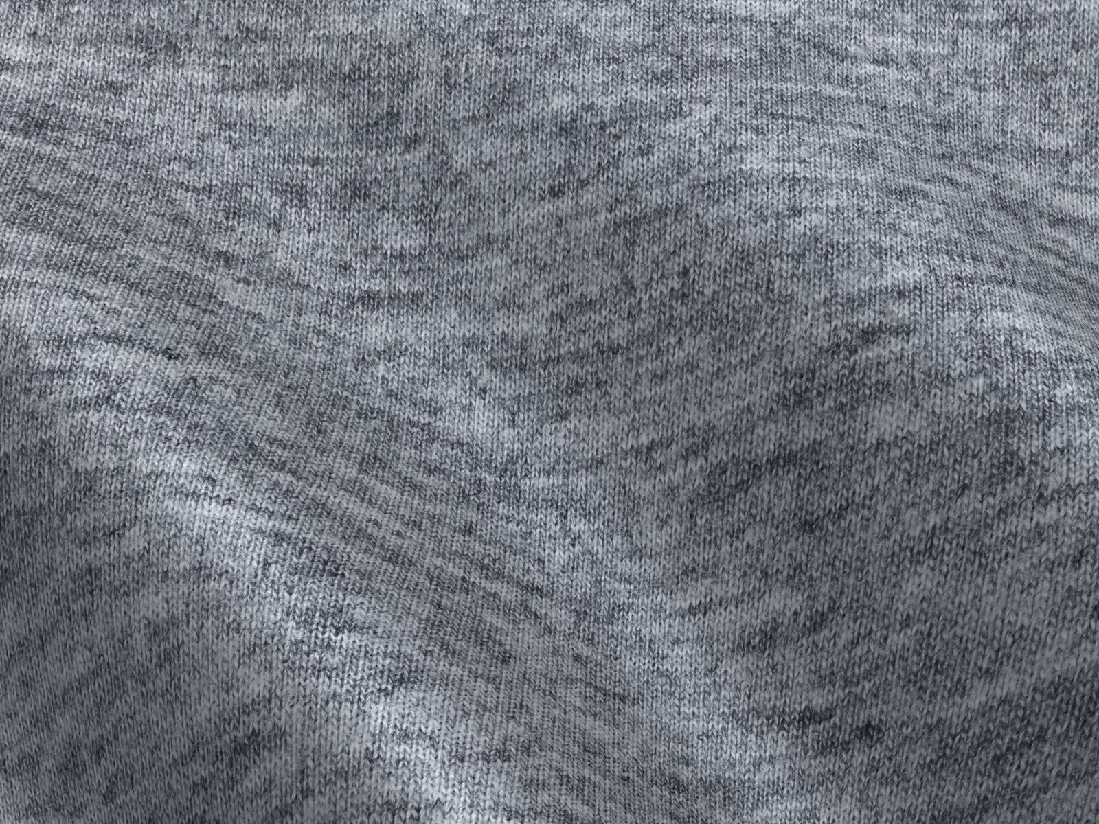 Close-up of soft gray knitted fabric, showcasing texture and gentle folds.